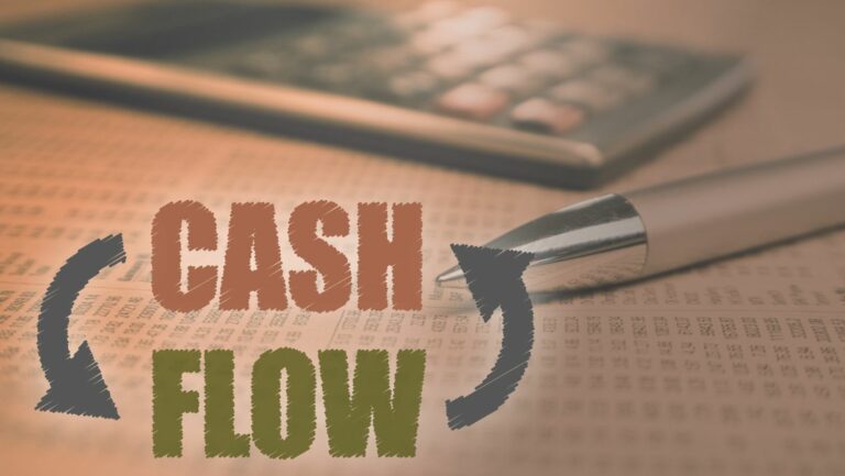 Cash flow calculator with a pen on a stack of paper.