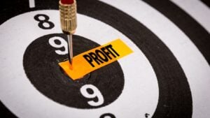 What does it mean to improve profitability? A dartboard with a piece of yellow paper labeled profit pinned with a dart.